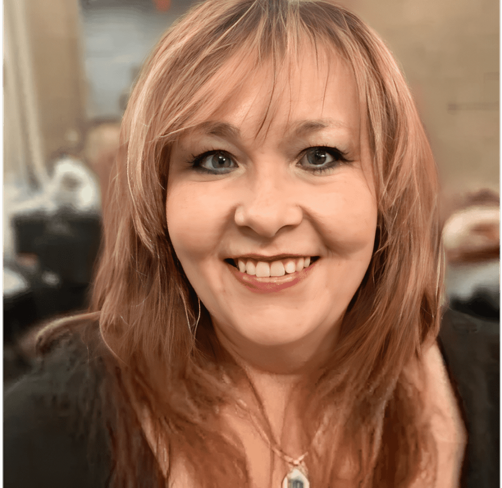 Woman smiling with a necklace visible.